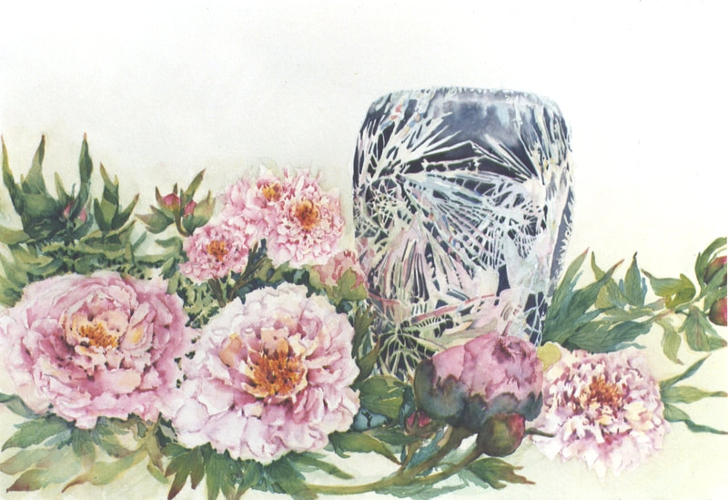 Pink peonies and leaves on the table beside a crystal vase