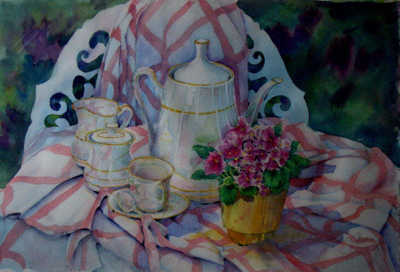 Tea setting for two with small post of African Violets on red & white checkered  table cloth 